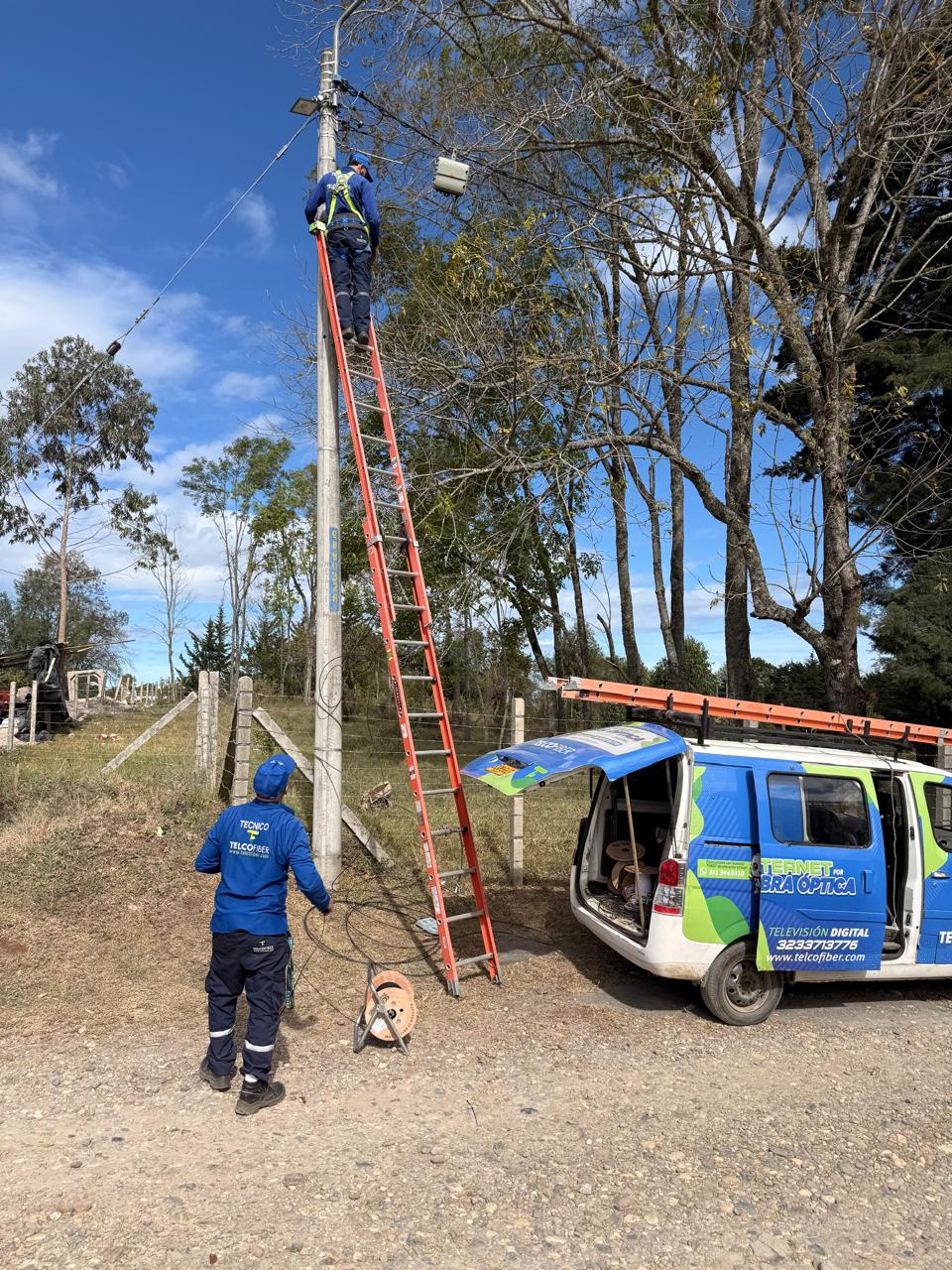 Técnico Telcofiber instalando fibra óptica en poste